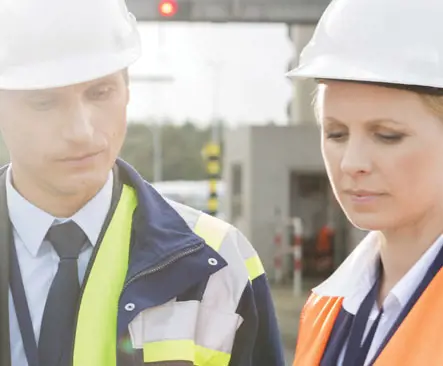 Two people wearing hard hats at a construction site